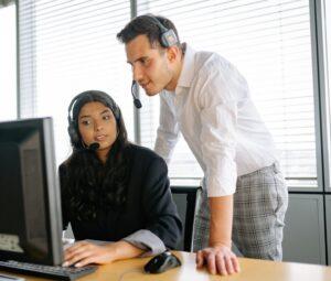 a man and woman looking at the computer screen